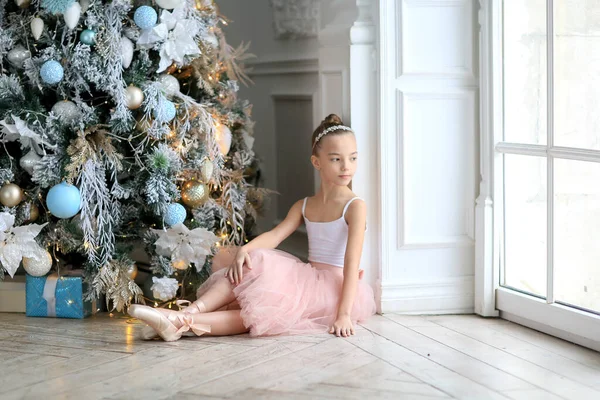 Ein Ballerina Mädchen Tutu Rock Und Spitzenschuhen Neben Dem Weihnachtsbaum Stockbild