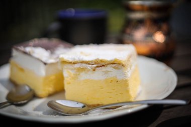 Kırsal kahvaltı. Kahve fincanlı ahşap kahve masası, Céve gölü kremalı pasta, lezzetli Slovenian tatlıları. Kremna Rezina veya Cremeschnitte