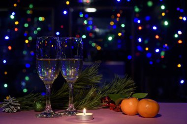 Masada iki bardak şarap var. Yılbaşı ışıkları ve dekorasyonları.
