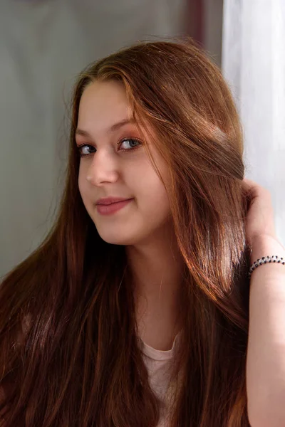 Retrato de una chica con cabello lujoso y fluido. Foto vertical — Foto de Stock