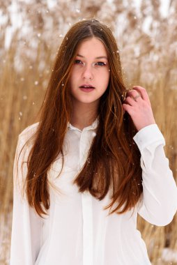 Kışın parkta güzel bir genç kız. Kış manzarası.