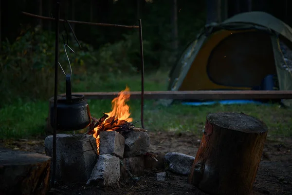 Чайник стоїть над вогнем у лісі. Копчений чайник над вогнем . — стокове фото