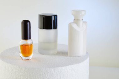 El kremi, parfüm, duş jeli, beyaz, yuvarlak bir podyumda etiketsiz şişeler için bir sürü boş el kremi..