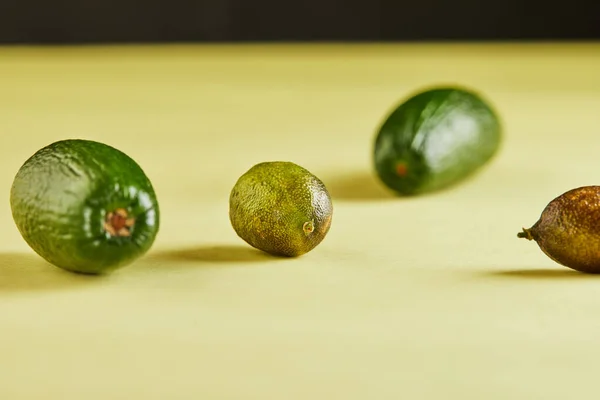 Reife Frische Mini Avocados Und Mini Zitronen Auf Gelbem Hintergrund — Stockfoto