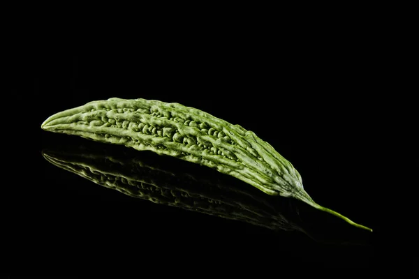 Melão amargo fresco isolado sobre fundo preto com reflexão — Fotografia de Stock