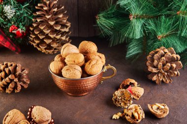 Dolgu ve kabukların yanında bir teneke bardakta ceviz var. Yeni yıl kompozisyonunda köknar kozalaklarıyla sunuldu. Kış hazırlıklarının ev deposu.