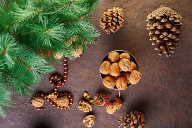 Dolgu ve kabukların yanında bir teneke bardakta ceviz var. Yeni yıl kompozisyonunda köknar kozalaklarıyla sunuldu. Kış hazırlıklarının ev deposu.