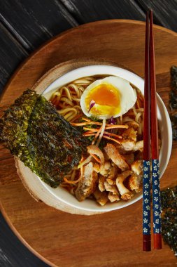 Japon eriştesi çorbası, tavuk, yumurta, sarımsak ve erişteli ve ahşap kaplama. Asyalı Miso Ramen eriştesi.