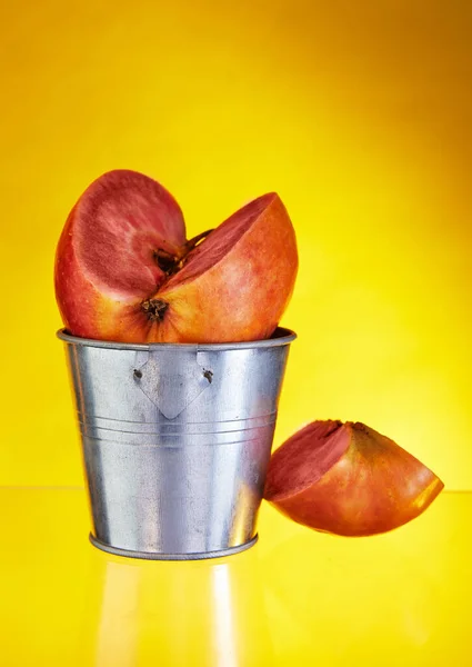 一个苹果 里面有红色的果肉 在桶的背面有一个雕刻的楔子 黄色背景隔离 异国情调的水果 健康食品 — 图库照片