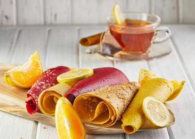 Meyveli börek ve limonlu çay ile sade meyveli tatlı pastille. Sağlıklı şekerler, lolipoplar, meyve cipsleri. Meyve ve meyvelerden elde edilen doğal tatlılar. Diyet vitamin ve vejetaryen yemekleri.