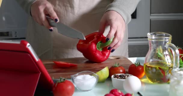 Online sanal uzmanlık kursuna göre yemek pişiren bir kadın ve dijital tarife bakıp evde mutfakta sağlıklı yemek pişirirken dokunmatik ekran tableti kullanan bir kadın. — Stok video