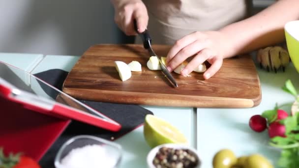 Tbetween koken volgens de tutorial van online virtuele masterclass, En kijken naar het digitale recept, met behulp van touchscreen tablet tijdens het koken van gezonde maaltijd in de keuken thuis — Stockvideo