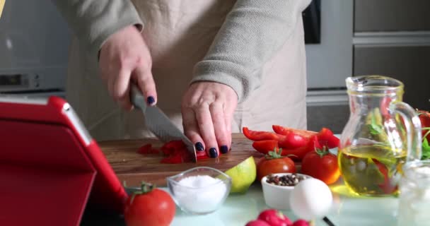 Donna cucina secondo il tutorial di classe master virtuale online, E guardando sulla ricetta digitale, utilizzando tablet touchscreen durante la cottura pasto sano in cucina a casa — Video Stock