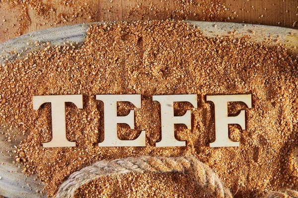 Teff, an alternative to ancient gluten-free grain with the name written in wooden letters. Teff has become a popular choice for healthy eating.