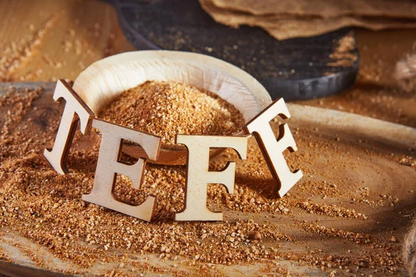 Teff, an alternative to ancient gluten-free grain with the name written in wooden letters. Teff has become a popular choice for healthy eating