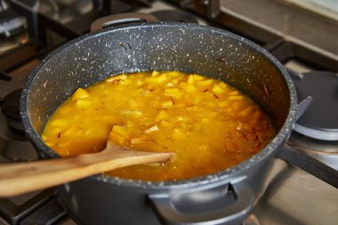 İnternetteki tariflere göre mutfakta yemek pişirmek. Kadın tavada risotto karıştırıyor. Adım adım tarif.