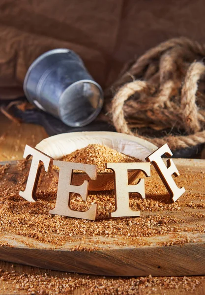 Teff, an alternative to ancient gluten-free grain with the name written in wooden letters. Teff has become a popular choice for healthy eating.