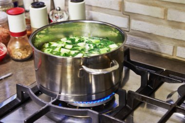 İnternetteki tariflere göre mutfakta yemek pişirmek. Gaz ocağında kaynamış krema çorbası tenceresi. Adım adım tarif.