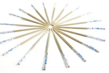 Tahta çubuklar, beyaz arka planda güneş şeklinde istiflenmiş örnekler..