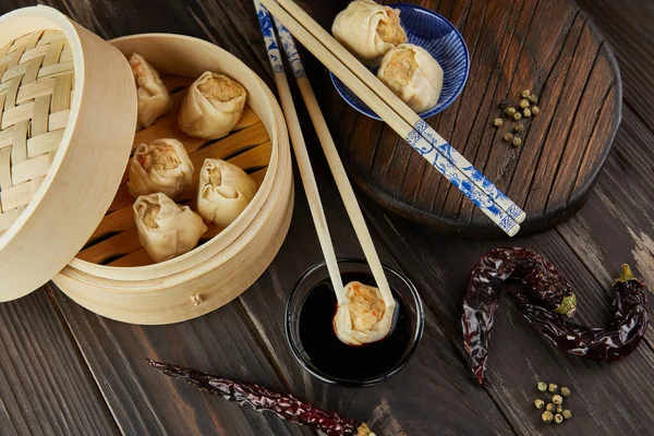 Shumai shaomai Chinese meat dumpling steamed dish in bamboo steamer box. Chopsticks and dimsum.