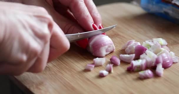 Frau schneidet rosa Mini-Zwiebel auf Schneidebrett in der Küche — Stockvideo