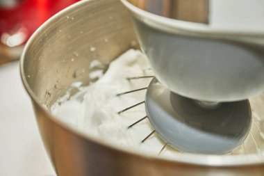 Kadın hamuru mikserle dövüyor ve internetten adım adım peynirli turta yapıyor.