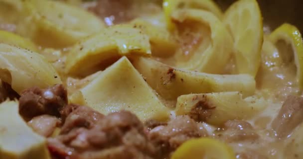 La carne joven de ternera con limón y patatas se hierve en un caldero grande, hirviendo y burbujeando — Vídeo de stock