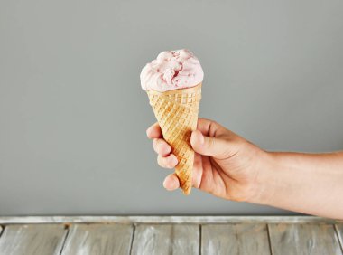 Gri arka planda dondurmalı waffle külahı.