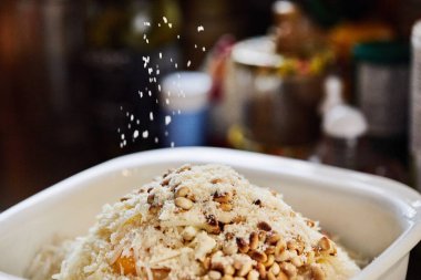 Parmesan peyniri kabın içindeki malzemelere pazılı turta yapmak için ekleniyor. Adım adım tarif.