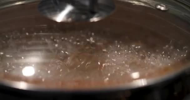 Coperchio di una padella per friggere con ebollizione liquida sotto esso — Video Stock