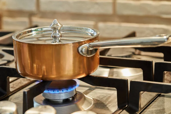 Copper saucepan over low heat on stove to make sauce — Stock Photo, Image