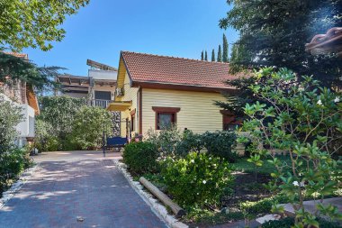 Ağaçlarla, çalılarla ve davetkar bahçelerle çevrili, ahşap cepheli, rahat bir eve giden yol..