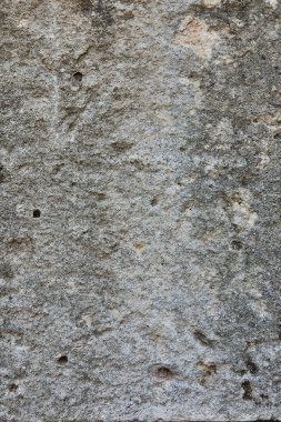 Gri taş yüzey, arka planda veya mimari tasarım uygulamalarında kullanılmak üzere doğal dokular ve küçük delikler içerir.