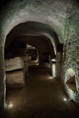 Aydınlatılmış yollar ve taş yapıları barındıran yeraltı mağara sistemi, tarihi bir arkeolojik alanda eşsiz jeolojik oluşumları vurguluyor.