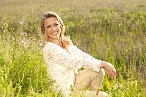 Mulher feliz no campo de flores — Fotografia de Stock