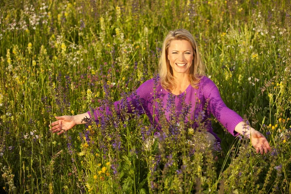 Счастливая женщина на цветочном поле — стоковое фото
