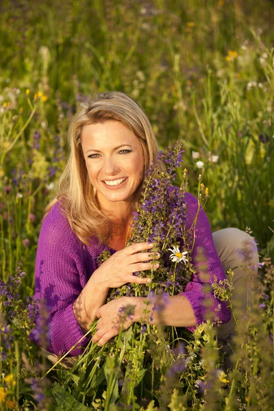 Glückliche Frau im Blumenfeld — Stockfoto