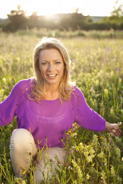 Glückliche Frau im Blumenfeld — Stockfoto