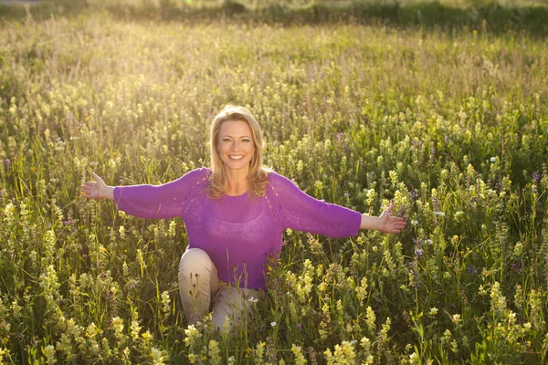 Glückliche Frau im Blumenfeld — Stockfoto