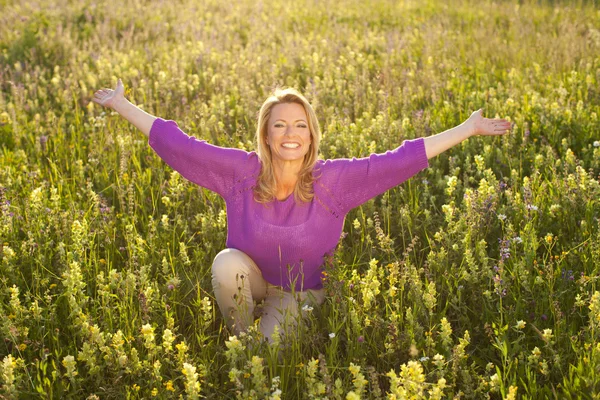 Femme heureuse dans le champ de fleurs — Photo