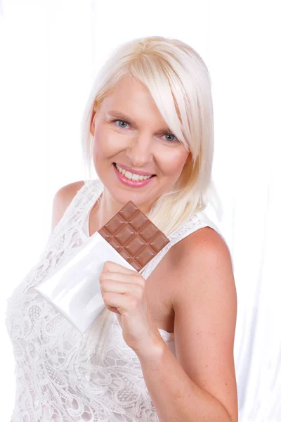 Молодая женщина держит плитку шоколада — стоковое фото