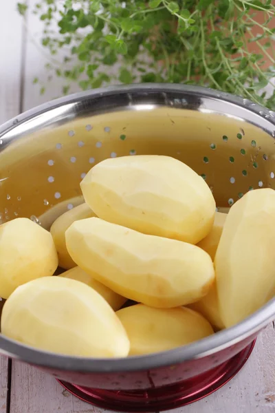 Peeled potatoes in a colander — Stock Photo, Image