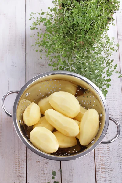 Peeled potatoes in a colander — Stock Photo, Image