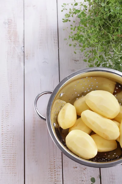 Peeled potatoes in a colander — Stock Photo, Image