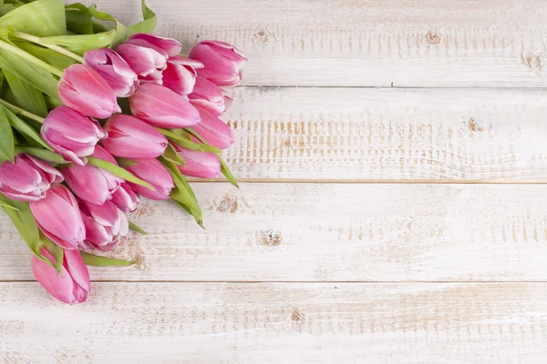 Ramo de tulipanes rosados en una tabla de madera — Foto de Stock