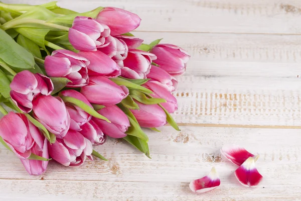 Banda růžové tulipány na dřevěném prkénku — Stock fotografie