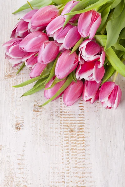 Bos van roze tulpen op een houten bord — Stockfoto