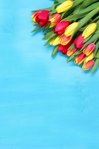Bouquet de tulipes rouges et jaunes avec fond en bois — Photo