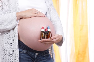 Homeopatik tıp küçük şişe ile hamile kadın