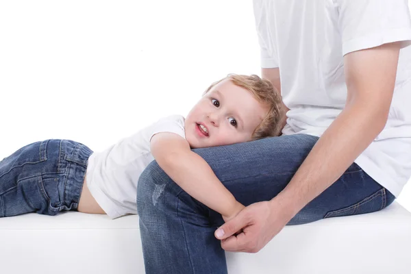 Liten pojke liggande i knät på sin far — Stockfoto